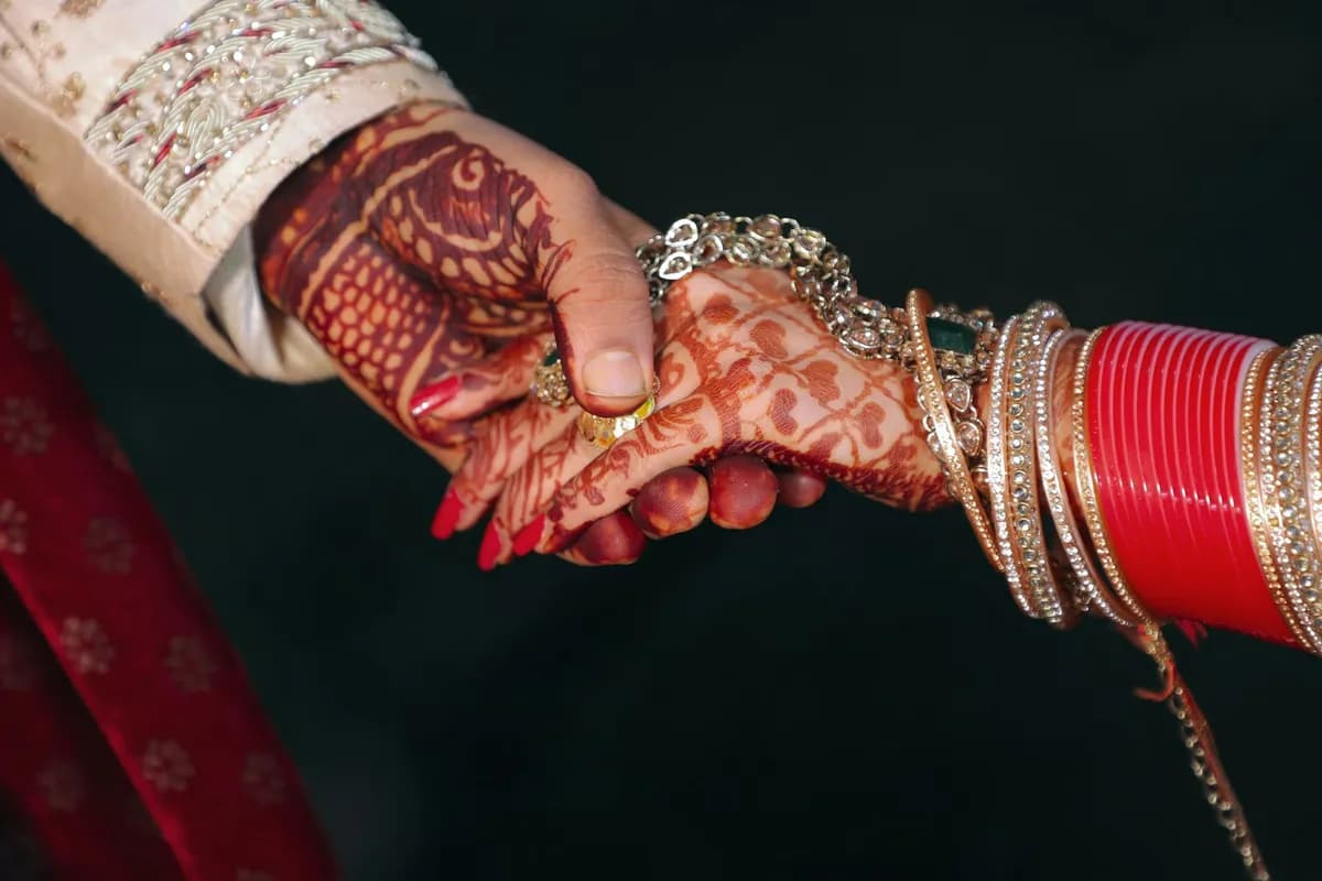 Hands with henna holding each other