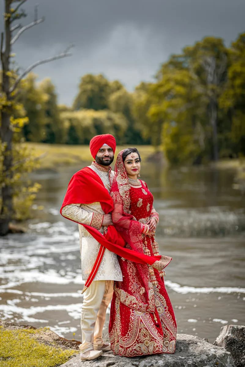 Couple in wedding attire by a river