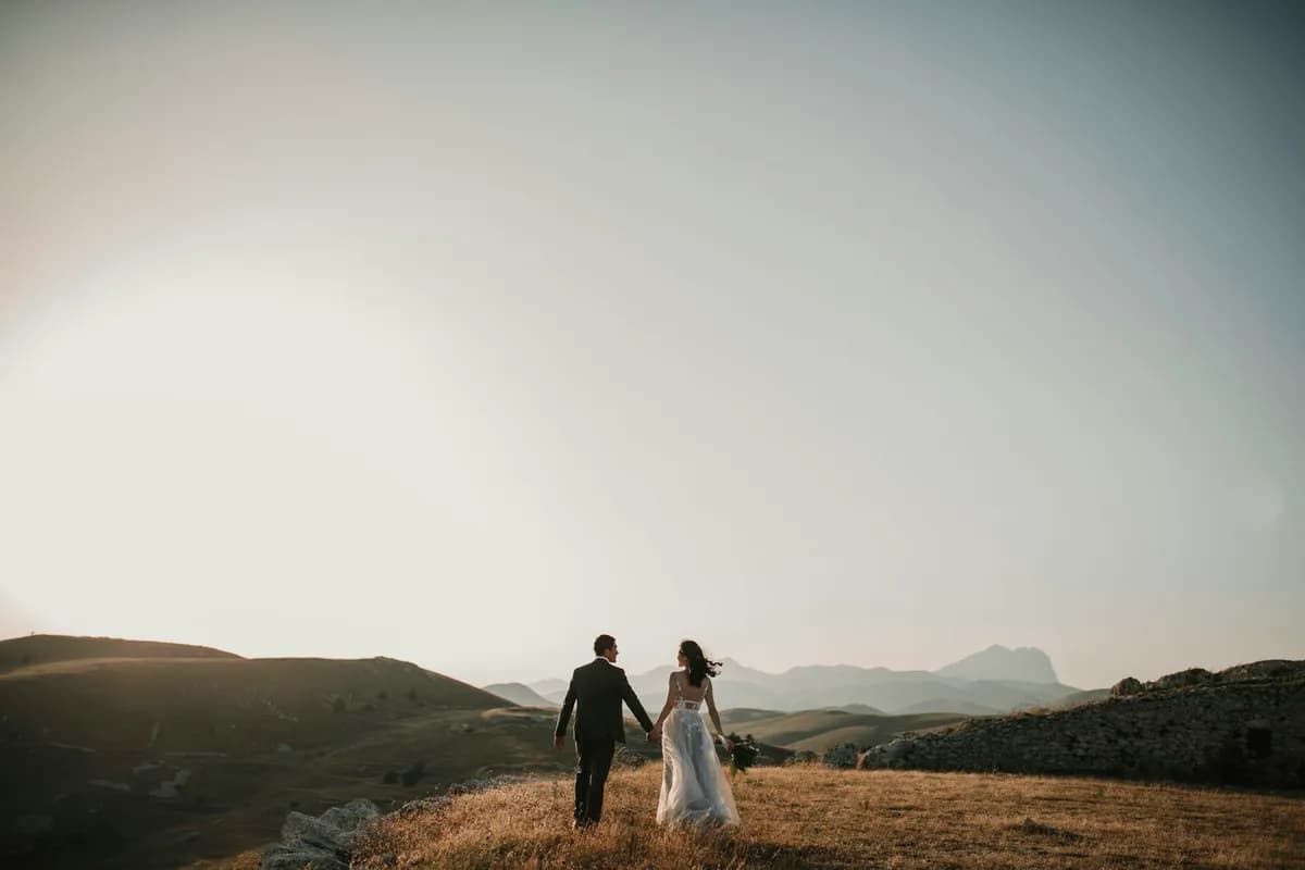 Couple walking across a hillside at dusk